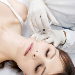 woman laying down getting an injection in the face